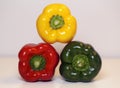 Green, Yellow and Red Fresh Bell Peppers on a White Surface Royalty Free Stock Photo