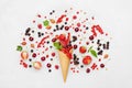 Colorful berries in waffle cone on light background from above. Dietary and healthy dessert. Flat lay styling.