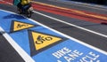 Colorful bicycle road sign and bike lane with motion blur of motorcycle on asphalt road surface Royalty Free Stock Photo