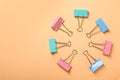 Colorful binder clips on beige background, flat lay. Space for text Royalty Free Stock Photo