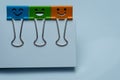 Colorful binder clips on white papers, happiness character. Royalty Free Stock Photo