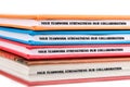 Colorful binders feature a motivational phrase about teamwork and collaboration arranged in a neat stack on a light background