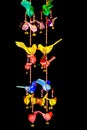 Colorful bird hangings on black background Royalty Free Stock Photo