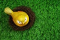 Colorful bird statue with nest on artificial green grass Royalty Free Stock Photo
