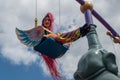 Colorful bird woman swinging in Festival of Fantasy Parade at Magic Kigndom 3.