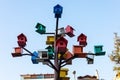 Vibrant birdhouses perched on a metal tree against the sky.