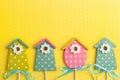 Colorful birdhouses on yellow polka dot background