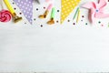 Colorful birthday accessories on white wooden background, flat lay. Space for