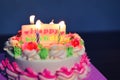 Colorful birthday cake with candles lights on table at night with label of happy birthday Royalty Free Stock Photo