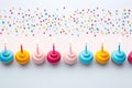 Colorful birthday cupcakes with candles placed in line. White background. Top view. AI Generated Royalty Free Stock Photo