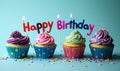 Colorful birthday cupcakes lined up with lit candles spelling Happy Birthday against a soft blue backdrop for festive Royalty Free Stock Photo