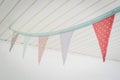 Colorful birthday flags in pastel colors hanging from a ceiling