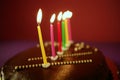 Colorful birthday light candles in chocolate cake