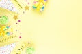 Colorful birthday party accessories on yellow. Wrapped gifts, confetti, balloons, party hats, decorations, copy space Royalty Free Stock Photo