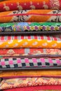 Colorful blankets and quilts placed in a stack in bright and vibrant orange and red colors