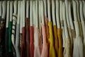 colorful blouses hanging on white hangers, arranged by color