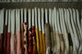 colorful blouses hanging on white hangers, arranged by color