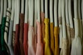 colorful blouses hanging on white hangers, arranged by color