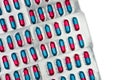 Colorful of blue, pink capsule with granule in side pills. Pills in blister pack on white background with space. Pharmaceutical