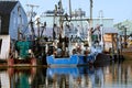 Colorful Blue and red fishing trawler sits idle in a protected h