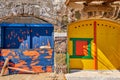 Colorful blue, yellow boat house doors, Klima fishermen village, Greece. Painted and weathered wooden doorways Royalty Free Stock Photo