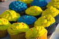 Colorful blue and yellow homemade cupcakes with sprinkles, minion concept party, desserts in blue and yellow color on a table