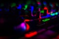 Colorful Blurred DJ Turn Table Jog Wheels with lots of turn knobs & bright cue button in dark Music Studio