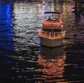 Colorful boat parade with lights reflecting in the water