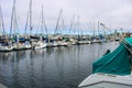 Colorful boats in marina with clouded skies and blue sky peeking out from behind the clouds