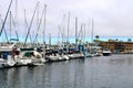 Colorful boats in marina with clouded skies and blue sky peeking out from behind the clouds