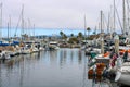 Colorful boats in marina with clouded skies and blue sky peeking out from behind the clouds