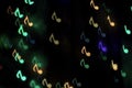Colorful bokeh on a dark background in the form of musical notes
