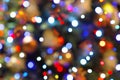 Colorful bokeh garland lights and Christmas tree toys defocused abstract blurred background. Royalty Free Stock Photo