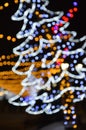 Colorful bokeh lights in the shape of a Christmas tree. Festive shiny background for celebrating Merry Christmas and Happy New Yea Royalty Free Stock Photo