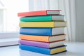 Colorful Books Stacked on Wooden Surface with Plant Background Royalty Free Stock Photo