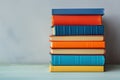Colorful Books Stacked on Wooden Surface with Plant Background Royalty Free Stock Photo