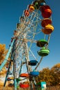 Multicolored booths of the devils wheel against the blue sky