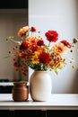 Colourful bouquet of autumn flowers in white vase stands on white table in the kitchen. Concept of style and minimalism in