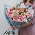 Colorful bouquet of different fresh flowers in the hands of florist woman. Rustic flower background. Craft bouquet of