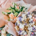 Colorful bouquet of different fresh flowers in the hands of florist woman. Rustic flower background. Craft bouquet of