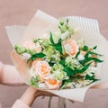 Colorful bouquet of different fresh flowers in the hands of florist woman. Rustic flower background. Craft bouquet of