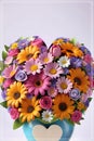 Bouquet of colorful flowers in a vase with a heart.