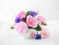Colorful bouquet of light pink roses and cornflowers on pale grey background