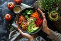 Colorful bowl with avocado and vegetables in a woman& x27;s hands