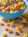 Colourful Bowl of Cereal Spilling Over Wooden Table Top Royalty Free Stock Photo