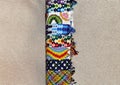 Colorful braided friendship bracelets with ties handmade of thread on stand for sale isolated on beige background with copy space