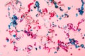 Colorful bright confetti and streamers on pink background, top view. Shining backdrop. Fun holiday mood. Happy Valentine day,