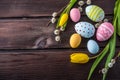 Colorful Easter eggs with yellow Tulip hand painted on a dark wooden background. Holiday spring card Royalty Free Stock Photo