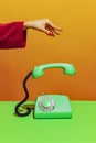 Colorful bright image of female hand holding old-fashioned green colored phone, handset falling down isolated over Royalty Free Stock Photo