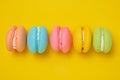 Colorful and bright macarons cookies yellow background